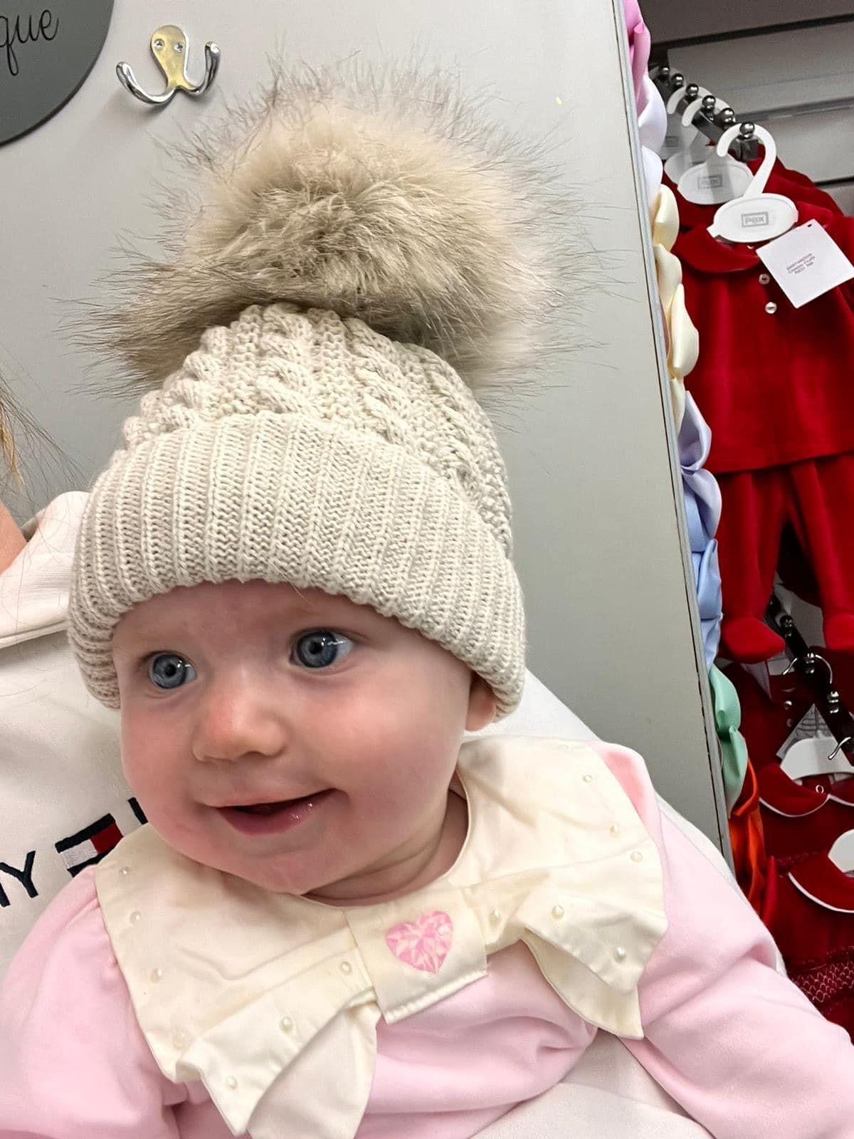 Beige knitted extra large pom pom hat